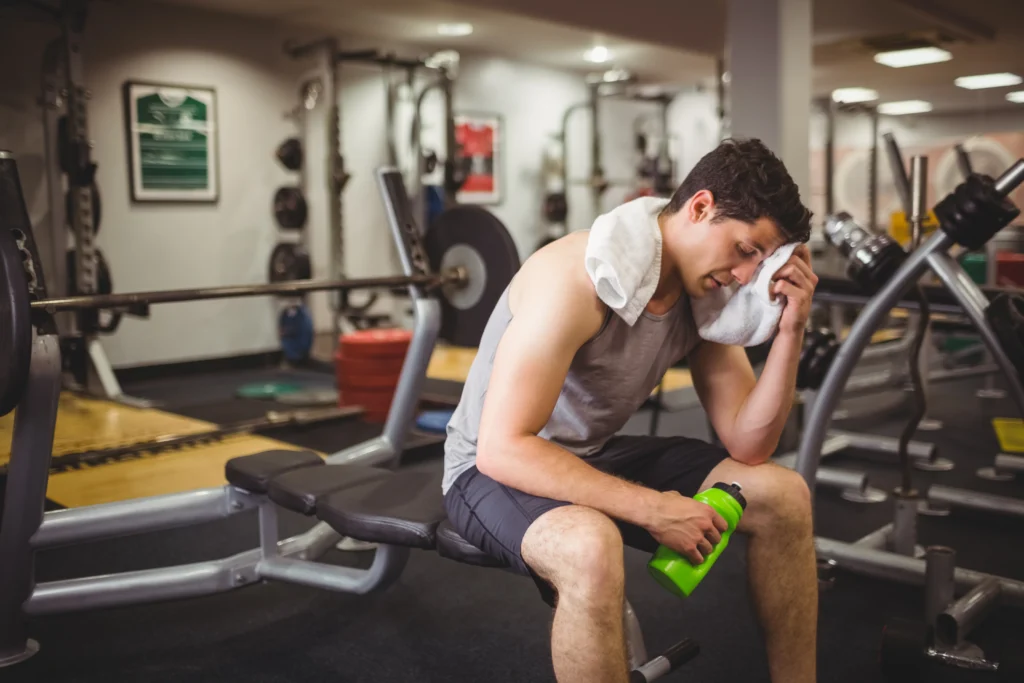Fit man taking a break from working out to rest and aid post workout recovery
